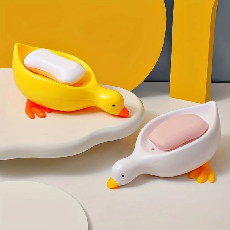 Yellow and white duck-shaped self-draining soap dishes